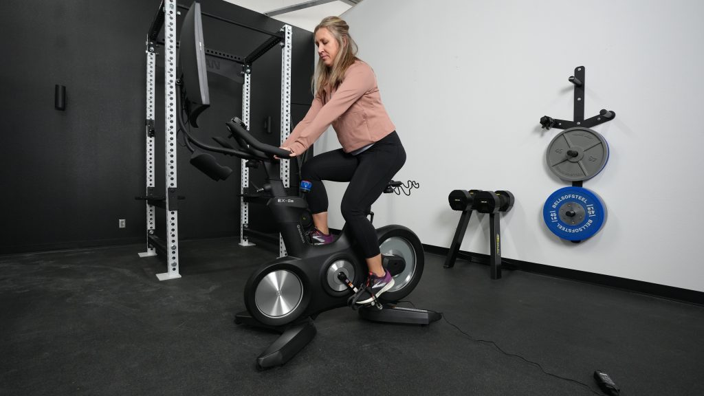 A BarBend tester riding the Echelon Connect EX-8s exercise bike.